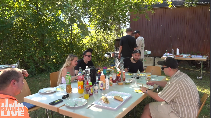 Community-Tisch: Essen, Trinken und FRED im Hintergrund
